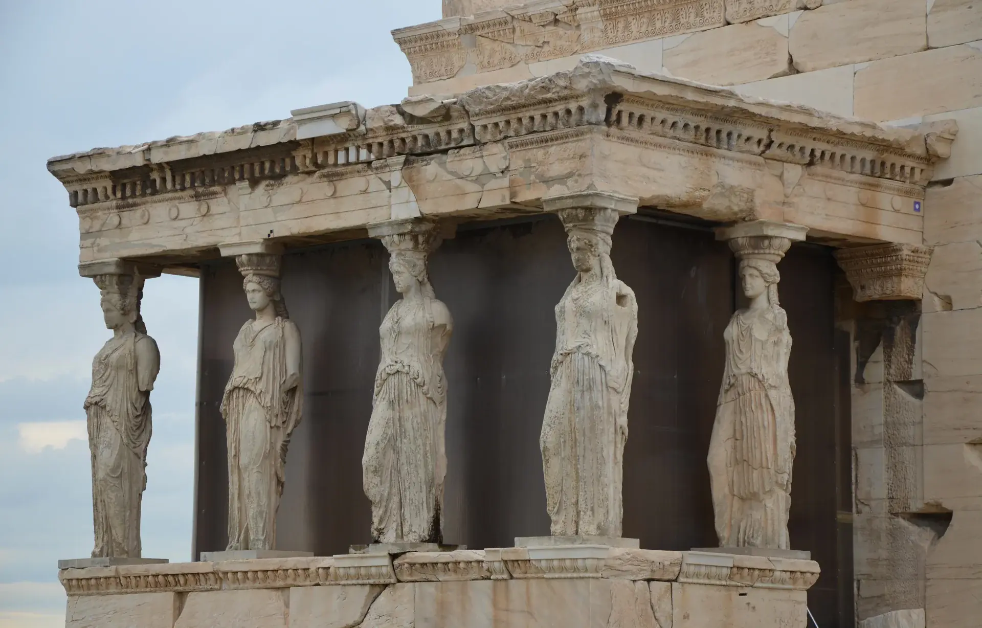 Vista de cerca del Pórtico de las Cariátides del Erecteión mostrando las seis elegantes columnas esculturales femeninas que sostienen el techo del templo