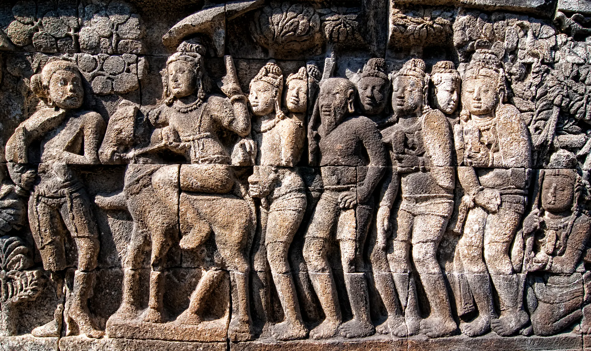 Paneles de relieves de piedra detallados en el Templo de Borobudur mostrando escenas narrativas budistas intrincadas con figuras, elementos arquitectónicos y motivos simbólicos tallados en estilo del siglo IX