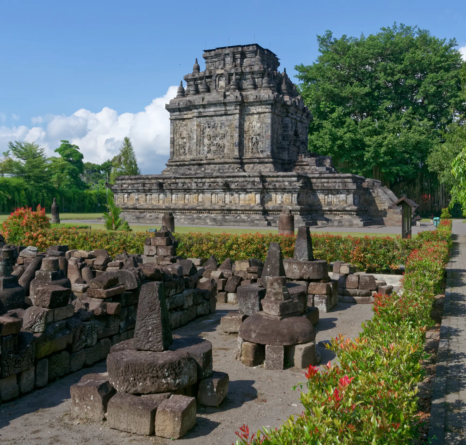 Templo de Mendut mostrando su estructura de piedra piramidal con escalera de entrada empinada y tallas de relieves intrincadas, parte del complejo del templo de Borobudur