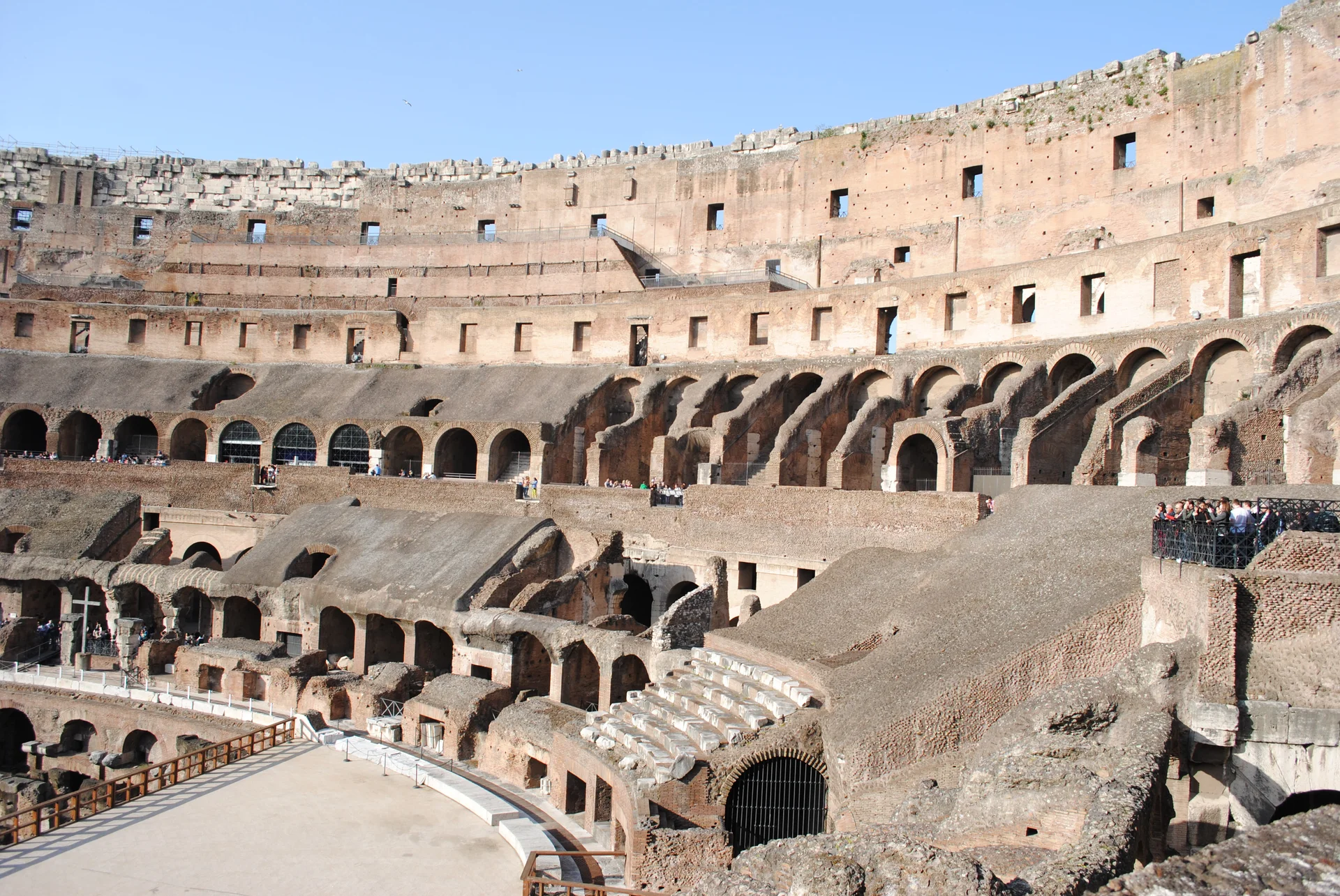 Vista interior del Coliseo mostrando el suelo de la arena parcialmente reconstruido con las cámaras del hipogeo subterráneo expuestas y los sistemas de túneles visibles debajo