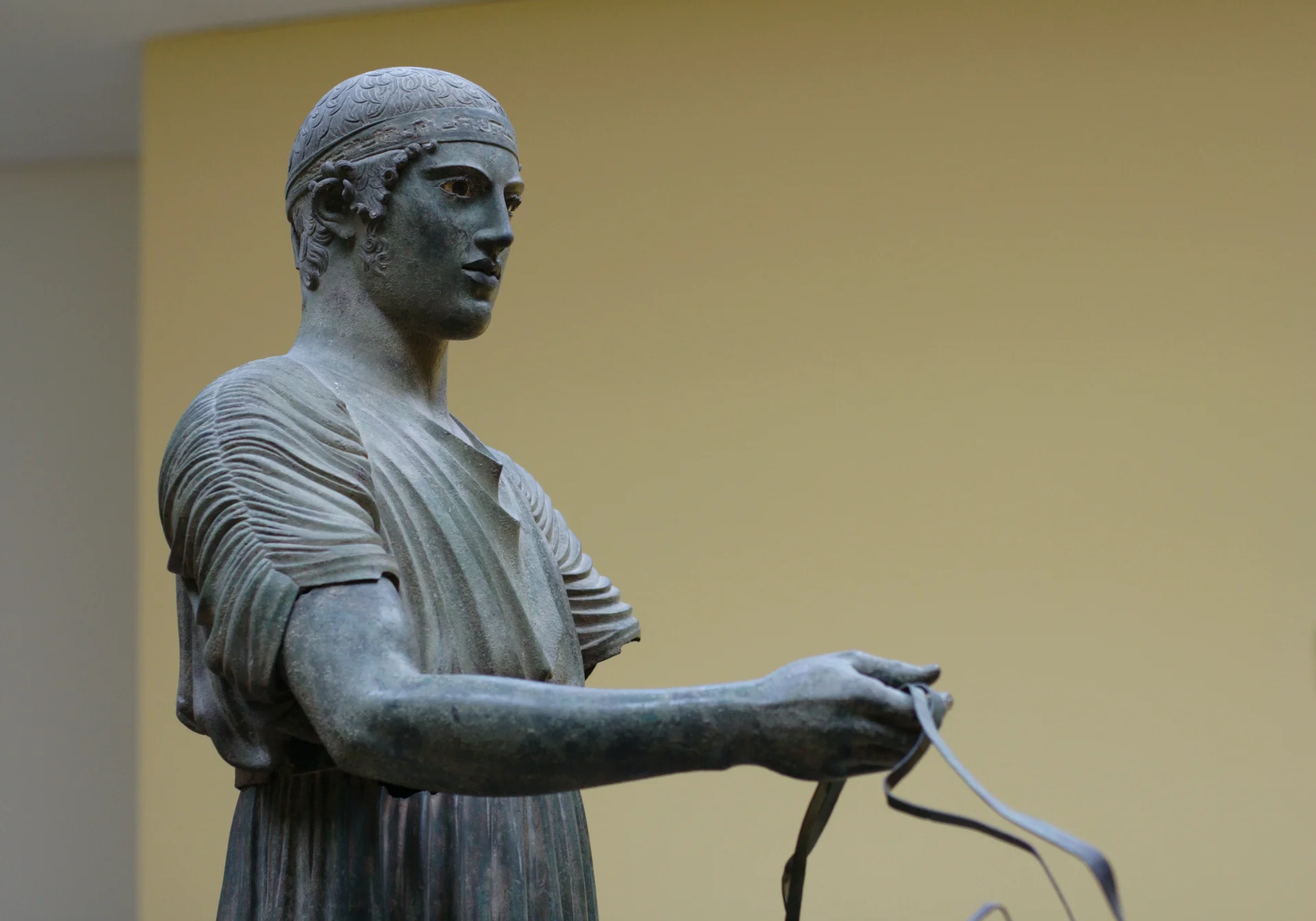 The famous Charioteer of Delphi bronze statue from 475 BC displayed in the archaeological museum, showing detailed ancient Greek sculpture craftsmanship