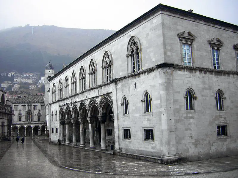 Fachada del Palacio del Rector mostrando arquitectura gótico-renacentista con columnas ornamentadas, arcos y trabajo decorativo en piedra en la Ciudad Vieja de Dubrovnik