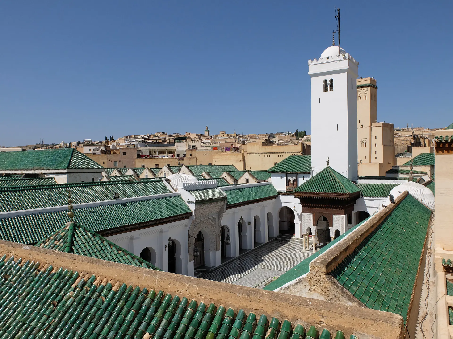 Exterior view of Al-Qarawiyyin University showing the ancient mosque complex with traditional Moroccan architecture and the famous minaret