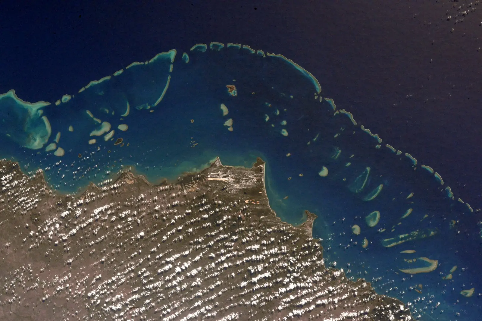 Stunning view from the International Space Station showing the Great Barrier Reef's immense scale with thousands of coral reefs visible from orbit