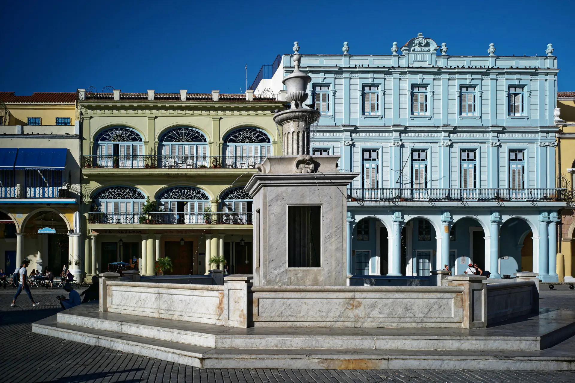 Coloridos edificios coloniales rodeando la Plaza Vieja en La Habana Vieja, mostrando las fachadas barrocas y Art Nouveau restauradas con sus distintivas arcadas y balcones