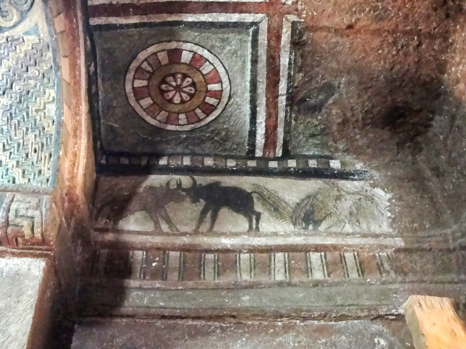 Interior of a Lalibela rock-hewn church showing carved columns, arched ceilings, and priests in white robes conducting religious ceremonies by candlelight