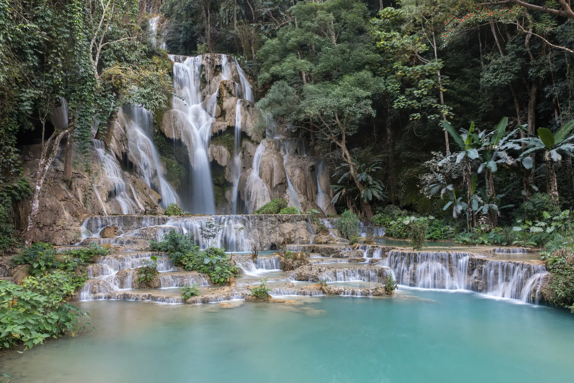 Cascadas Kuang Si de múltiples niveles con impresionantes piscinas azul turquesa cayendo en cascada a través de bosque tropical cerca de Luang Prabang