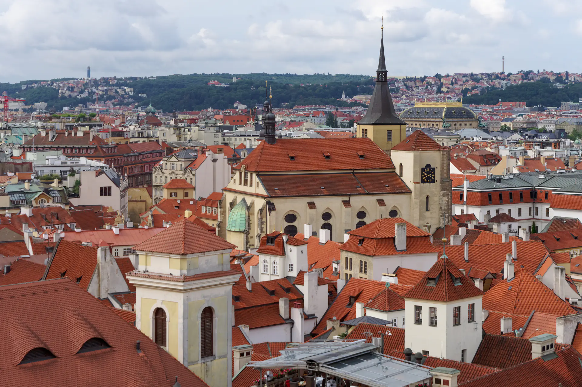 Vista panorámica del complejo del Castillo de Praga elevándose sobre el centro histórico con las torres de la Catedral de San Vito y techos de tejas rojas a través del río Moldava