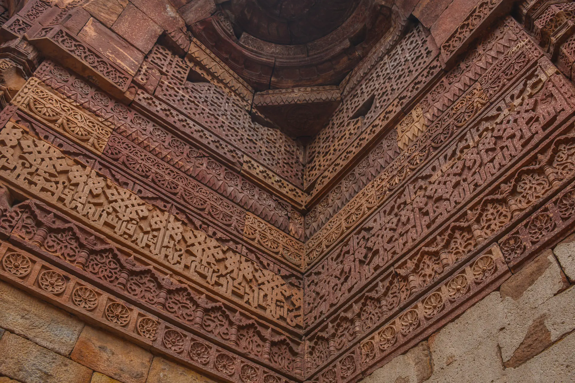 Interior de la tumba de Iltutmish mostrando intrincada talla en piedra con patrones geométricos, caligrafía y elaborada decoración de mihrab en cada superficie