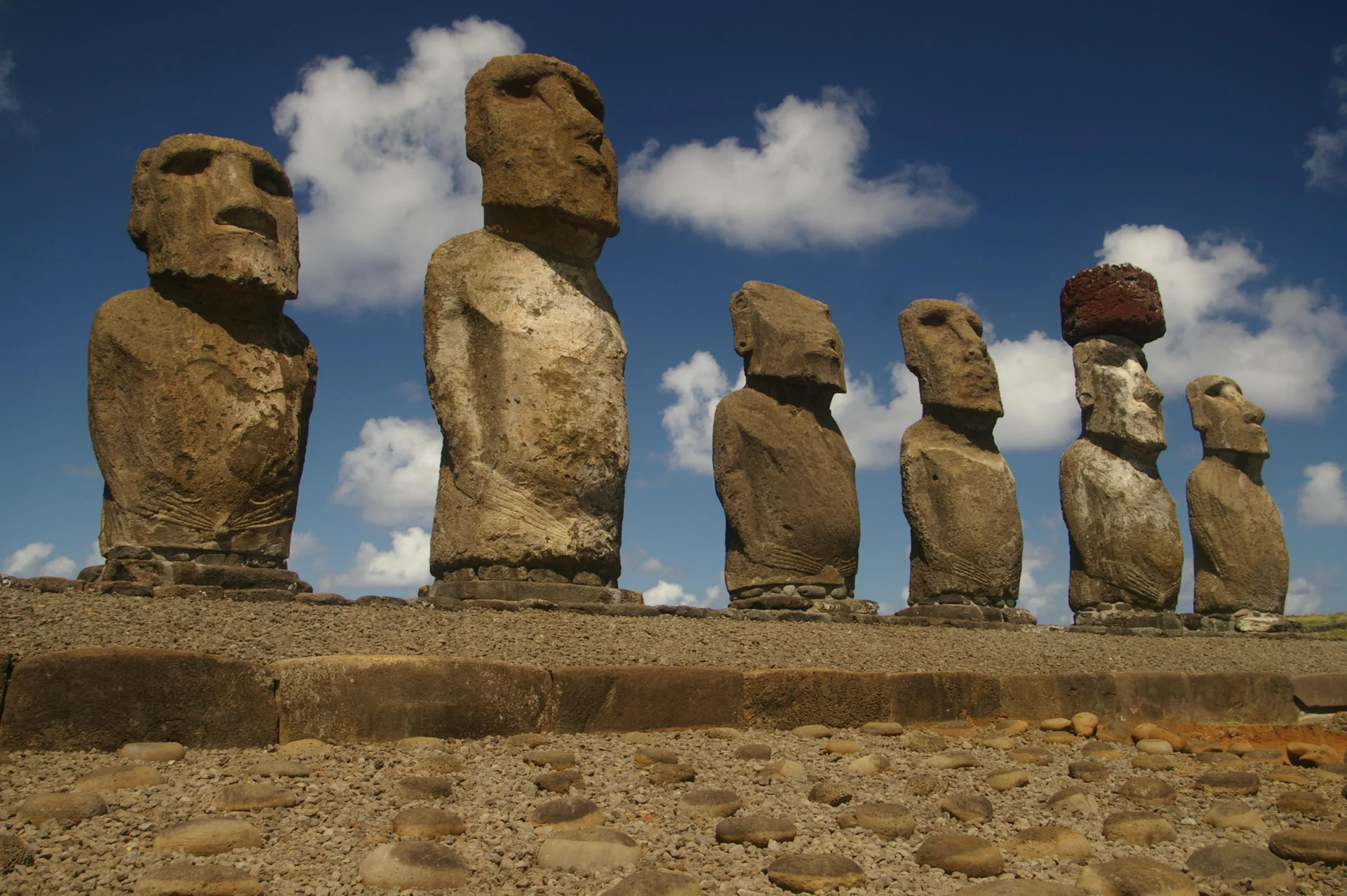Seis de las quince estatuas *moai* de la plataforma ceremonial Ahu Tongariki de pie contra el cielo azul