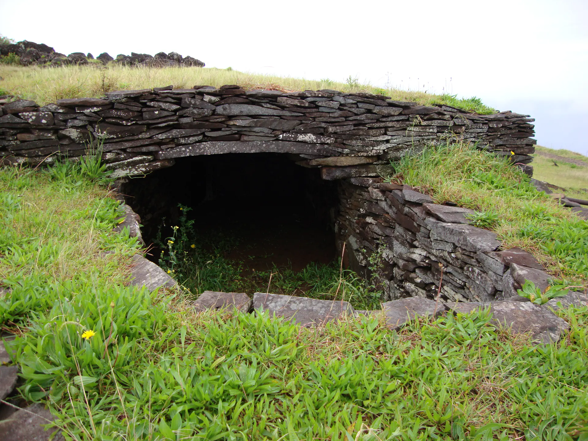 Casa de piedra de falsa bóveda parcialmente reconstruida en la aldea ceremonial de Orongo que muestra la técnica de construcción distintiva utilizada por los antiguos habitantes de Rapa Nui
