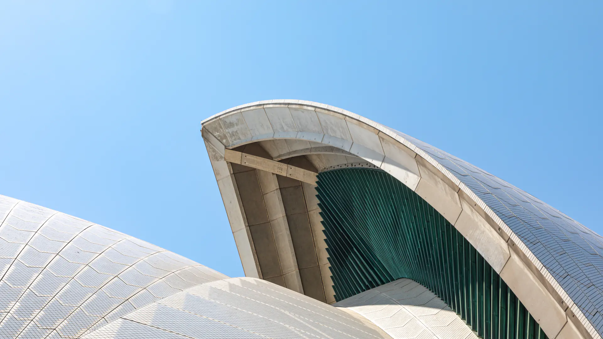 Vista de cerca de las estructuras de conchas de hormigón blanco de la Ópera de Sídney contra el cielo azul, mostrando detalles arquitectónicos