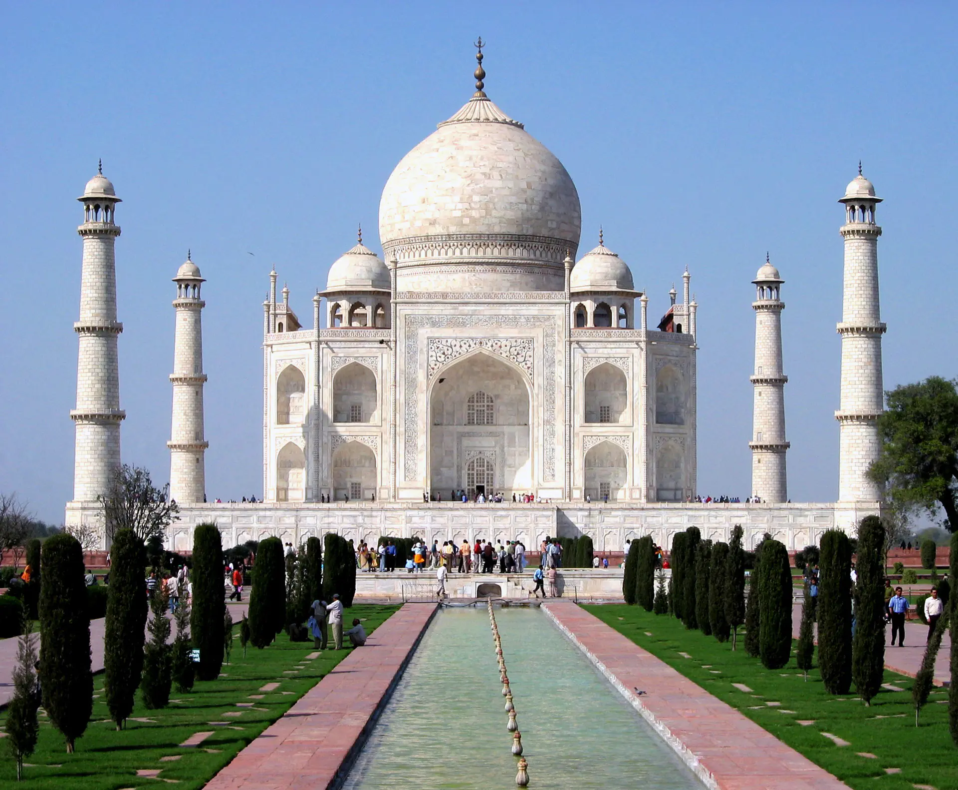 Vista de cerca de la prístina fachada de mármol blanco del Taj Mahal mostrando el intrincado trabajo floral de incrustación *pietra dura* y caligrafía islámica