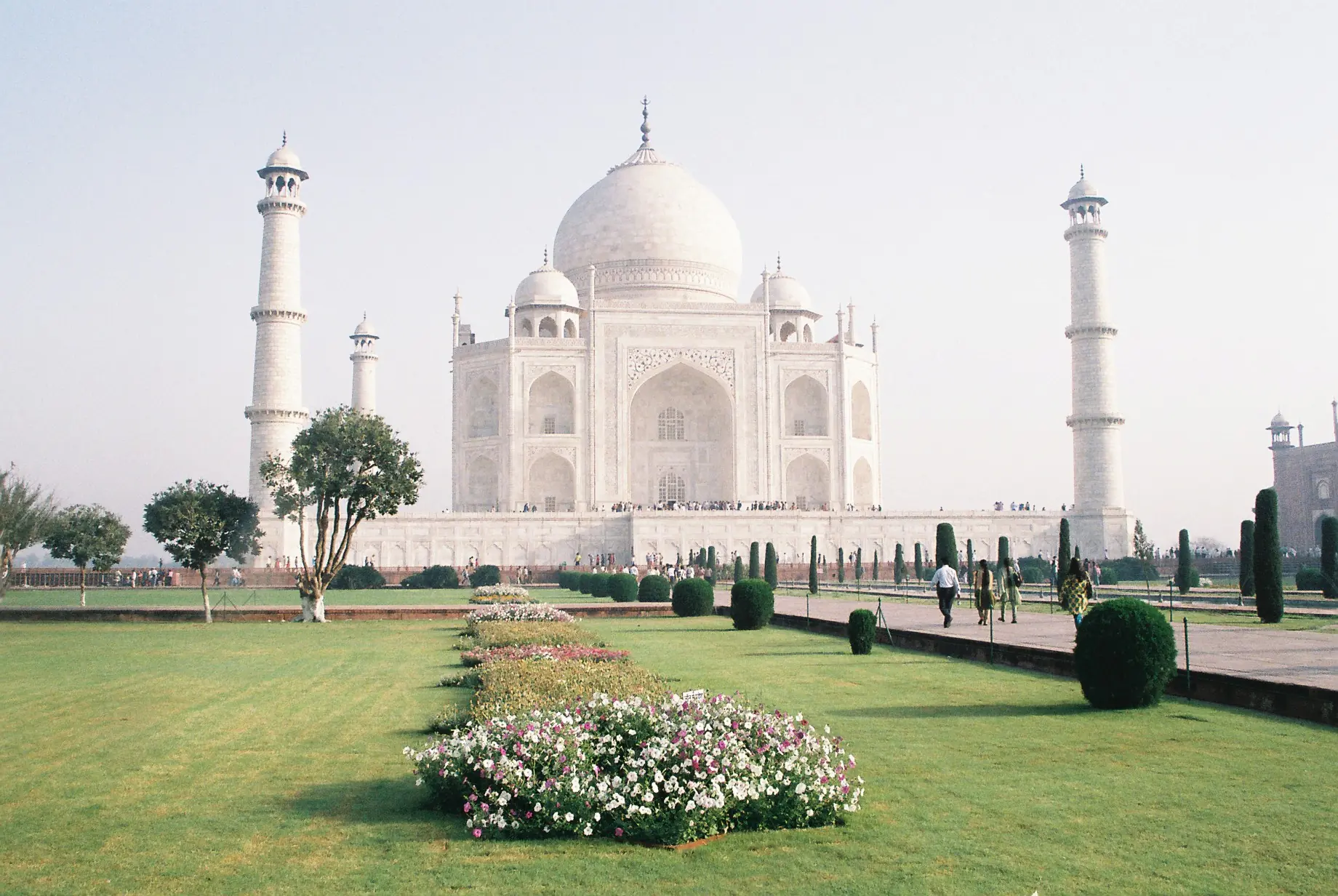 Los jardines formales mogoles del Taj Mahal con canales de agua geométricos y senderos que llevan al mausoleo de mármol blanco