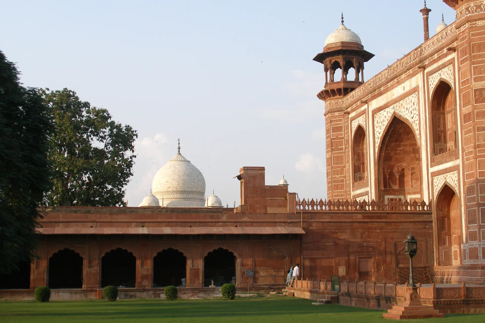 La imponente Gran Puerta de piedra arenisca roja entrada al complejo del Taj Mahal, adornada con intrincada caligrafía islámica e incrustaciones de mármol
