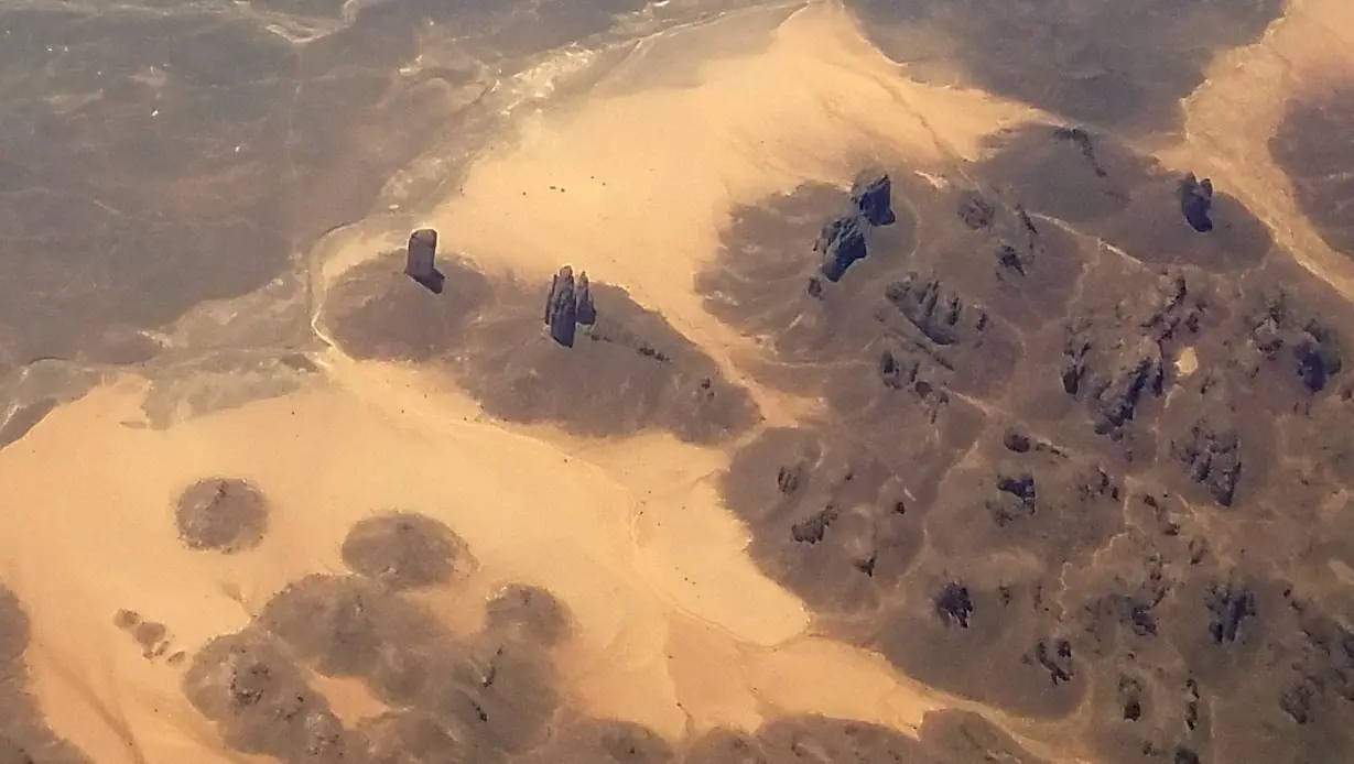 Columnas de arenisca erosionada imponentes que se elevan desde el suelo del desierto mostrando las distintivas formaciones de bosque de roca erosionada de Tassili n'Ajjer